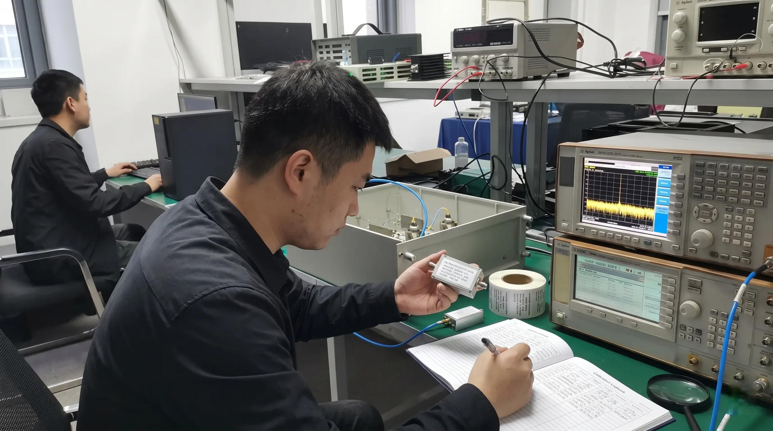 Engineer checking a calibration sticker on test equipment